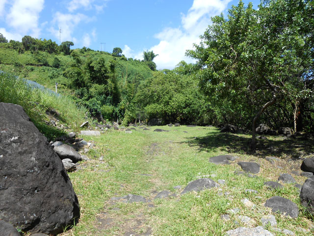 Début du sentier entre le mur de l'usine et la Rivière du Mât