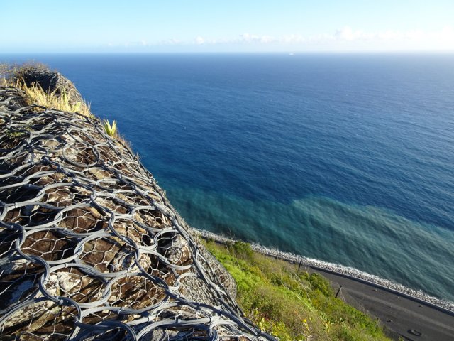 Point de vue sur la mer depuis les filets protégeant des chutes de pierres
